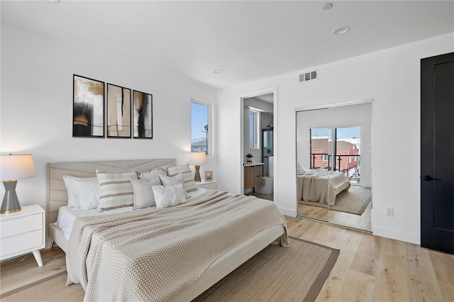 bedroom featuring light wood-type flooring and connected bathroom