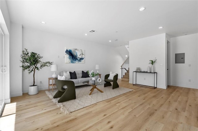 living room with electric panel and light hardwood / wood-style floors