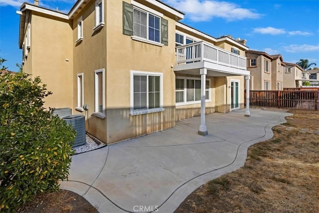 back of house with central air condition unit, a balcony, and a patio