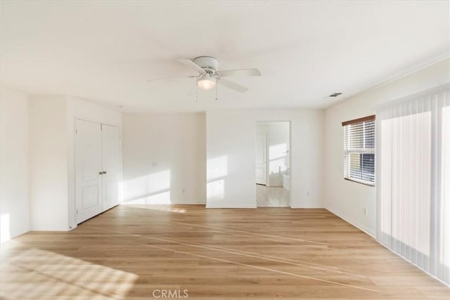 empty room with ceiling fan and light wood-type flooring