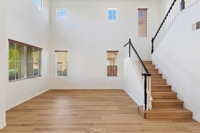 staircase with a high ceiling and hardwood / wood-style flooring