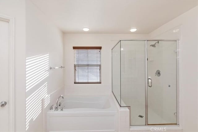 bathroom featuring shower with separate bathtub