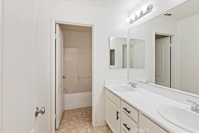 bathroom featuring tile patterned flooring, vanity, and tiled shower / bath combo