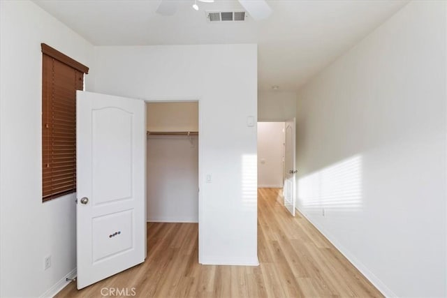 unfurnished bedroom featuring a closet, light hardwood / wood-style flooring, and ceiling fan