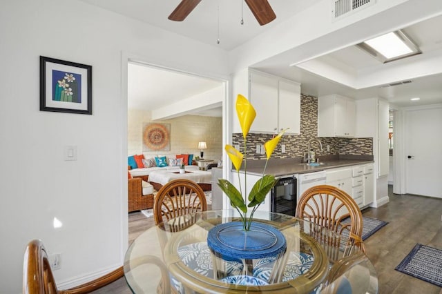 dining space with ceiling fan, dark hardwood / wood-style floors, beverage cooler, and sink