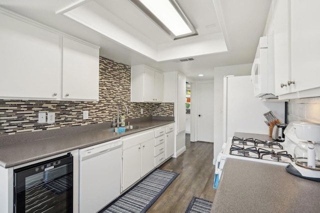 kitchen featuring white appliances, beverage cooler, dark wood-type flooring, sink, and white cabinets