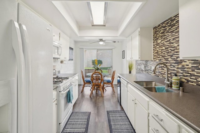 kitchen with white cabinetry, white appliances, and sink