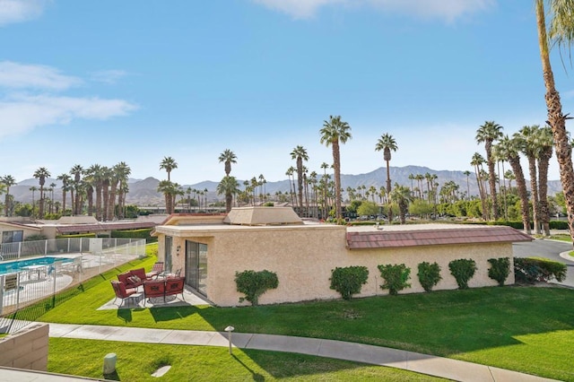 exterior space with a mountain view, a community pool, a patio, and a front lawn