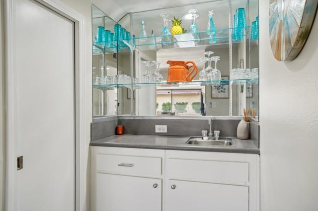 bar featuring white cabinetry and sink