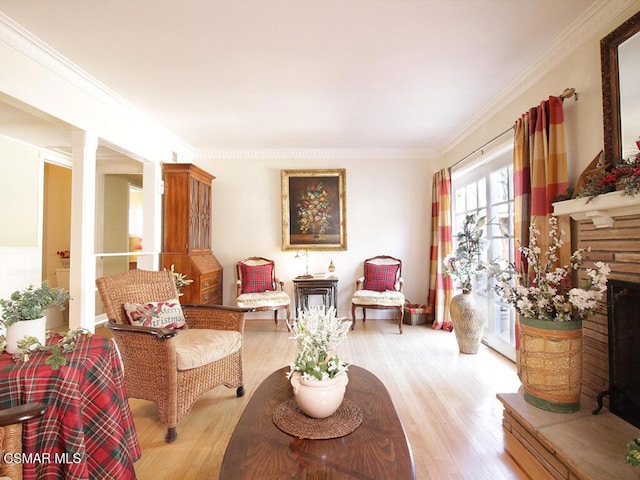 living area featuring light wood-type flooring and ornamental molding