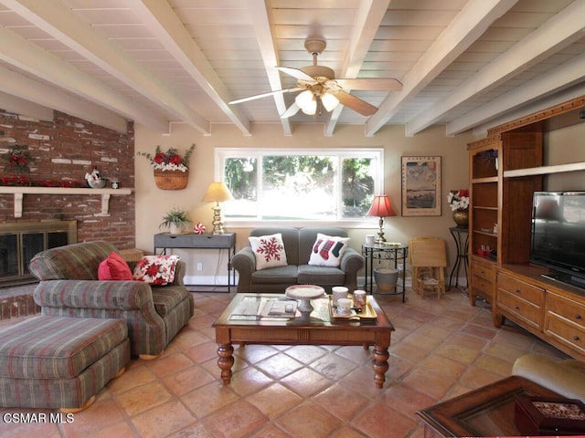 tiled living room featuring beam ceiling, ceiling fan, and a brick fireplace