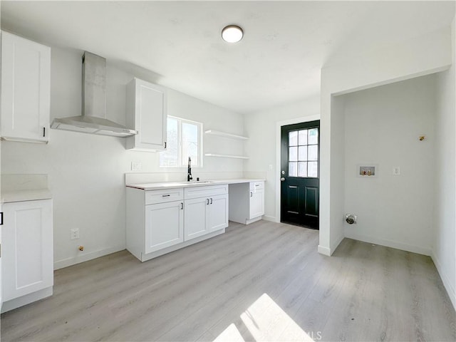 kitchen featuring white cabinets, wall chimney exhaust hood, and a healthy amount of sunlight