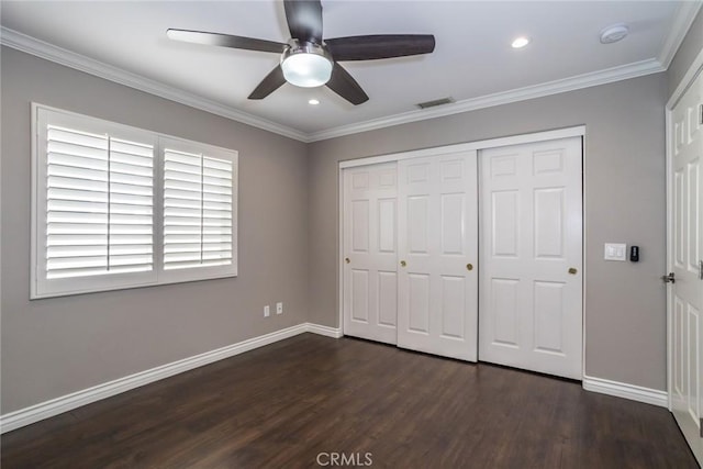 unfurnished bedroom with ceiling fan, a closet, dark wood-type flooring, and ornamental molding