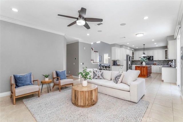 living room featuring ceiling fan, sink, light tile patterned floors, and crown molding