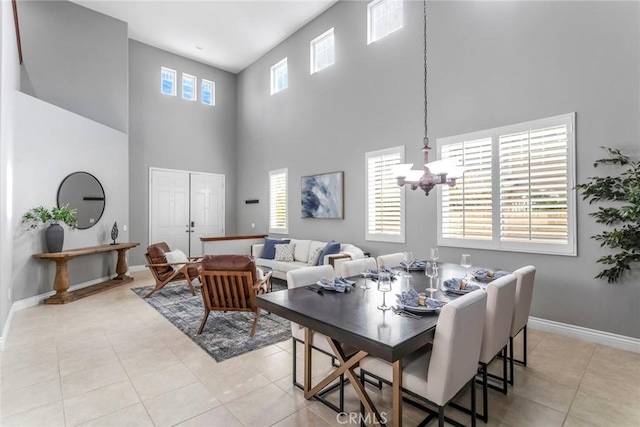 dining area featuring light tile patterned floors, a high ceiling, and a notable chandelier