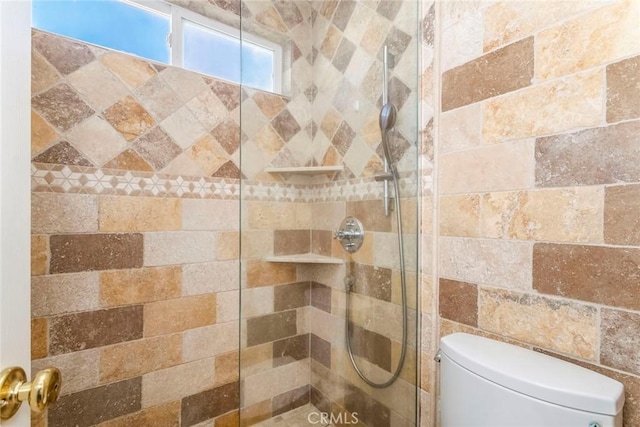 bathroom featuring toilet and tiled shower