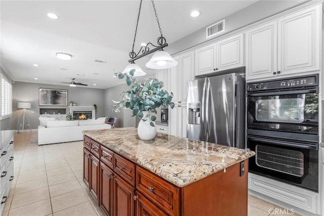 kitchen featuring stainless steel fridge, a kitchen island, double oven, white cabinetry, and hanging light fixtures