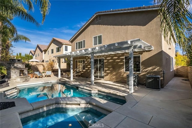 rear view of property featuring a pergola, a pool with hot tub, an outdoor stone fireplace, cooling unit, and a patio