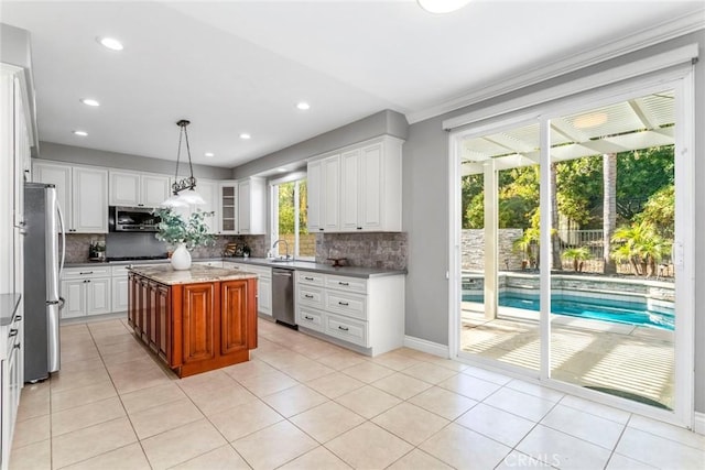 kitchen featuring white cabinets, appliances with stainless steel finishes, a center island, and pendant lighting