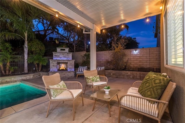 patio terrace at dusk with an outdoor stone fireplace