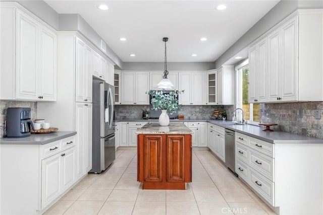 kitchen with sink, stainless steel appliances, white cabinets, pendant lighting, and a kitchen island