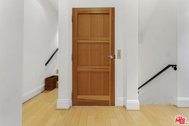 entryway with wood-type flooring and elevator