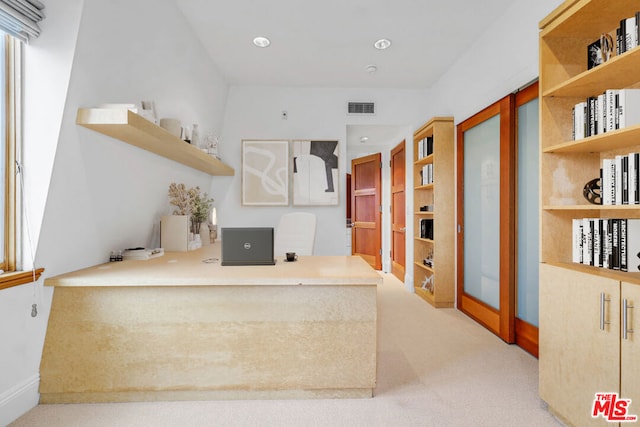 kitchen featuring light colored carpet and built in desk