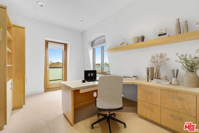 office space with built in desk and light carpet