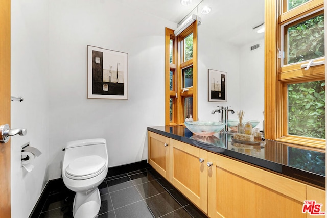 bathroom with tile patterned flooring, vanity, and toilet