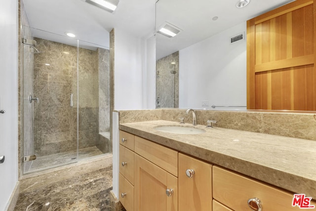 bathroom featuring vanity and a shower with door