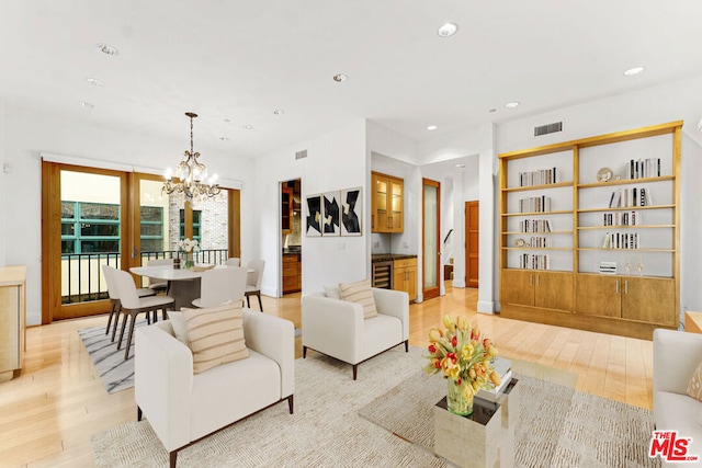 living room with light wood-type flooring, wine cooler, and a chandelier