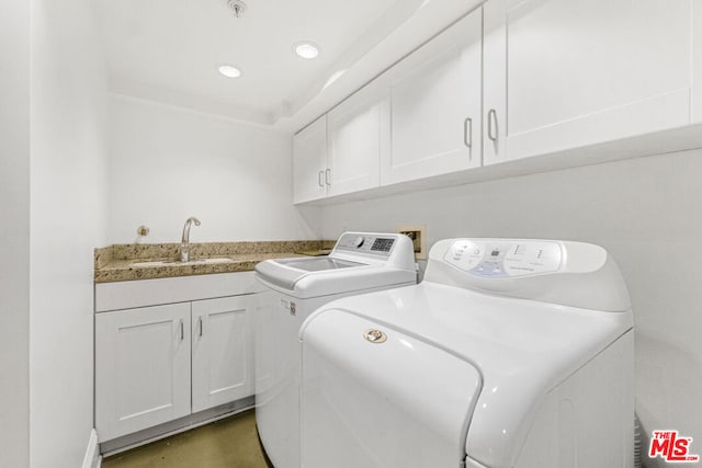 washroom featuring cabinets, sink, and washing machine and clothes dryer