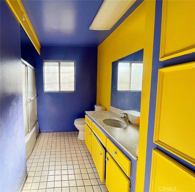 full bathroom featuring tile patterned floors, shower / bath combination with glass door, vanity, and toilet