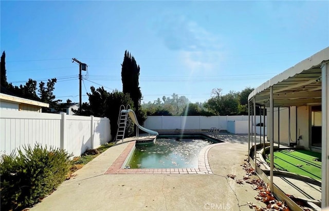 view of pool with a patio area and a water slide