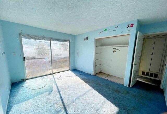 carpeted bedroom featuring a closet and a textured ceiling