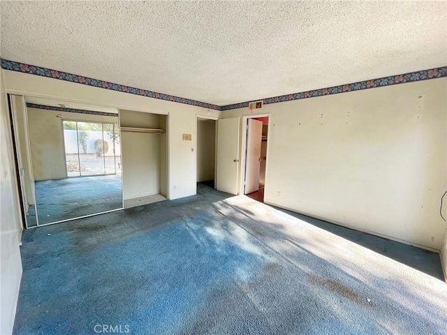 carpeted spare room featuring a textured ceiling