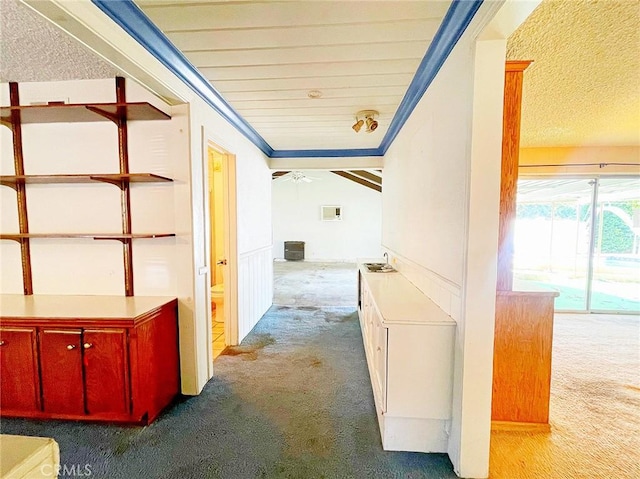 hallway with carpet, a textured ceiling, and crown molding