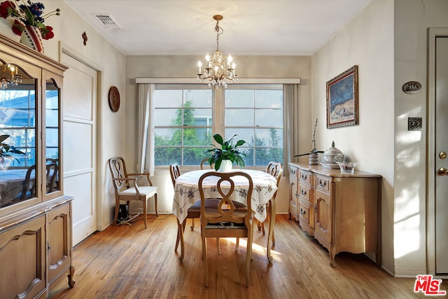 dining space with a notable chandelier and light wood-type flooring