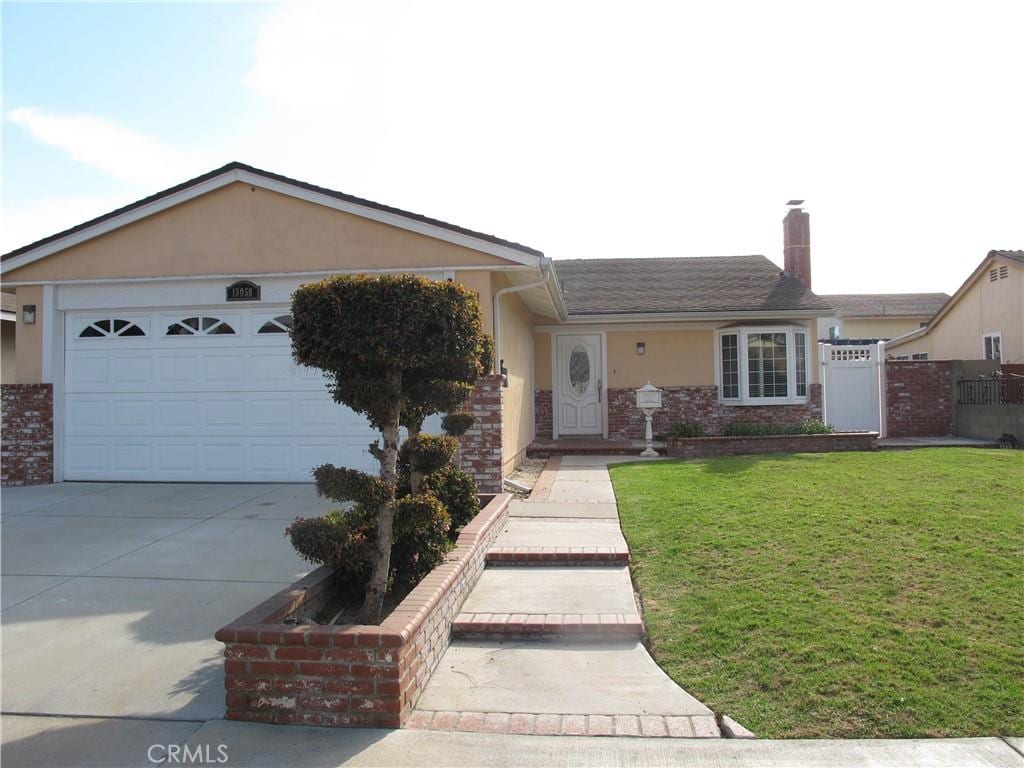 ranch-style house featuring a front yard and a garage