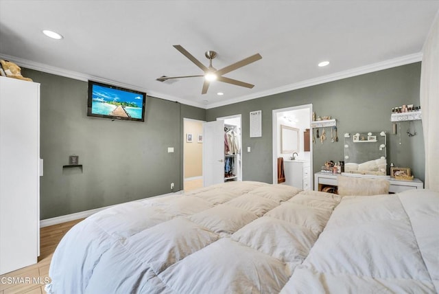 bedroom with ceiling fan, a spacious closet, crown molding, and light hardwood / wood-style flooring