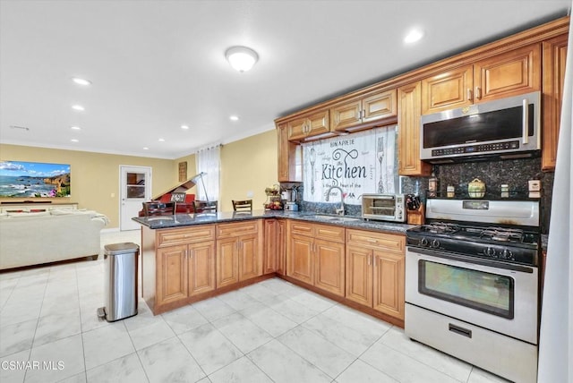 kitchen with sink, dark stone countertops, tasteful backsplash, kitchen peninsula, and gas range gas stove