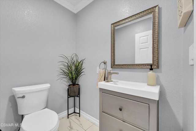 bathroom with vanity, ornamental molding, and toilet