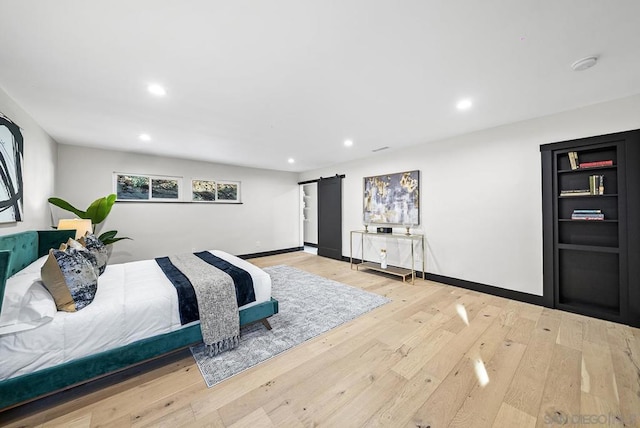 bedroom featuring light hardwood / wood-style flooring and a barn door