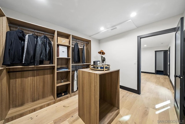 walk in closet with light wood-type flooring