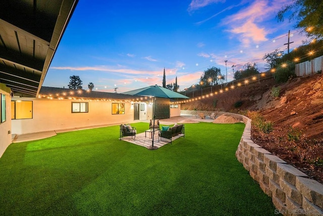 yard at dusk featuring a patio