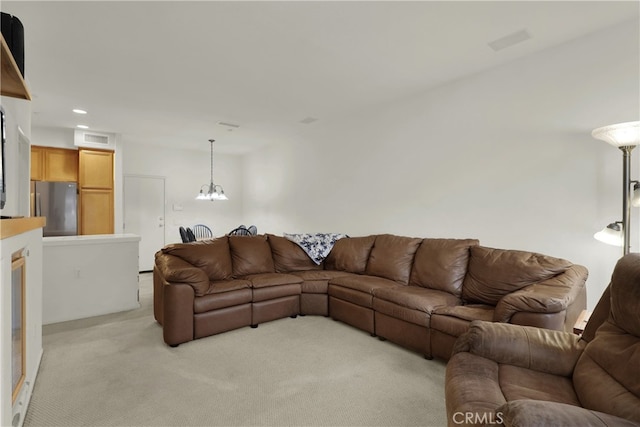 carpeted living room with a chandelier