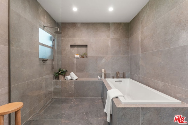 bathroom with independent shower and bath and tile walls