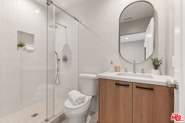 bathroom featuring an enclosed shower, vanity, toilet, and tile walls