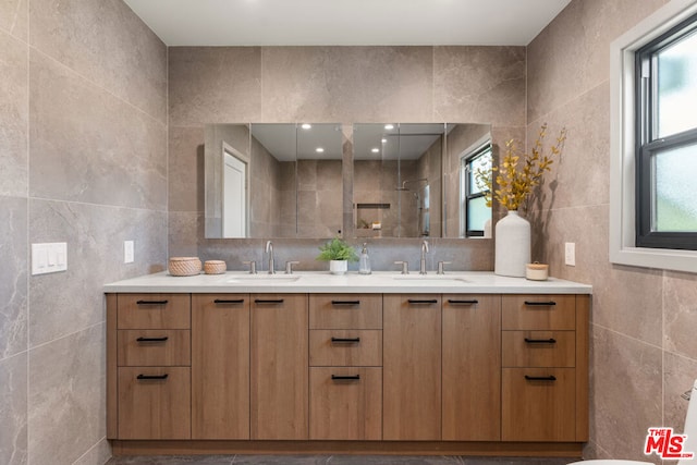 bathroom with a shower, vanity, and tile walls