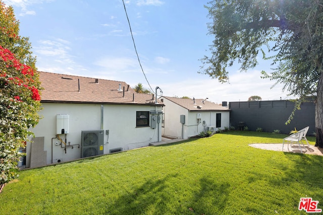 back of house with ac unit and a lawn